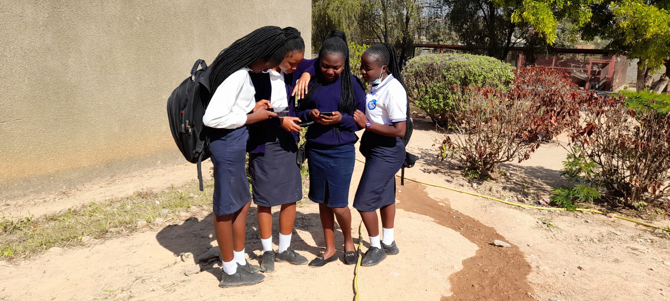 Les élèves consultent le téléphone dans la cour de l'école. Kipushi, 2021 @ponabana