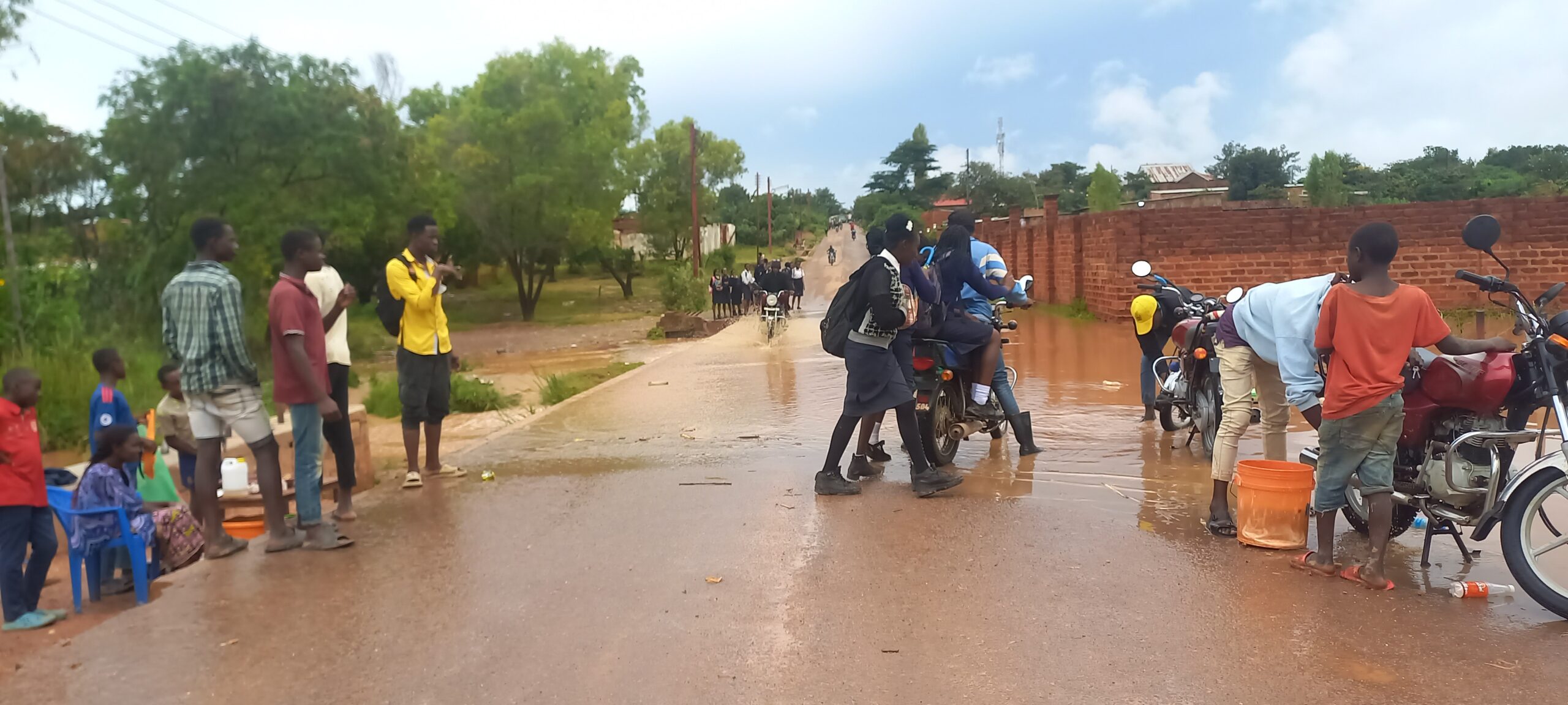 Des élèves de l'institut Mulumba Lukoji en train de traverser le pont Jordanie inondé, à moto